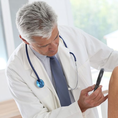 Dermatologist looking at patients skin